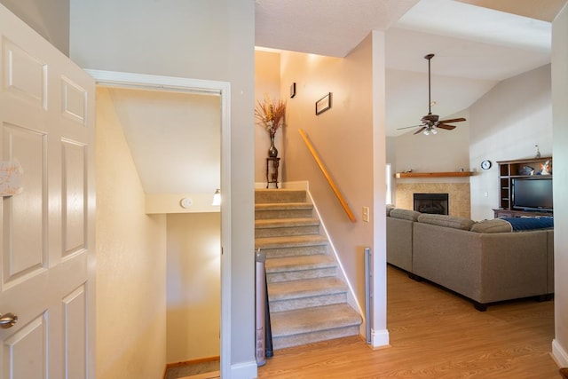 stairs featuring hardwood / wood-style floors, vaulted ceiling, and ceiling fan