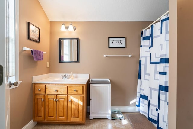 bathroom featuring vanity, lofted ceiling, and curtained shower