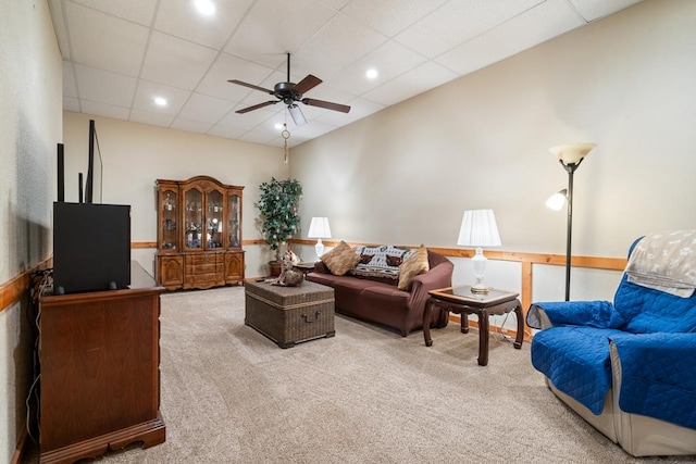 living room featuring ceiling fan, a drop ceiling, and carpet flooring