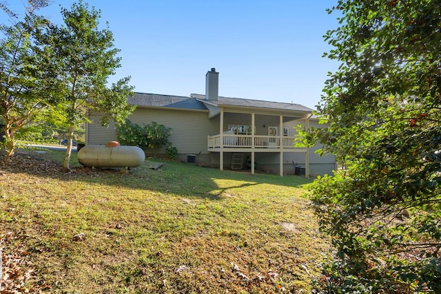 rear view of house with a lawn and central AC