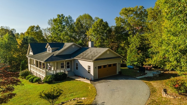 view of front of house with a garage, a front lawn, and covered porch