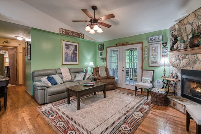 243 Havenwood Ln, Murphy, NC 28906 - living room featuring hardwood / wood-style floors, lofted ceiling, a ceiling fan, a stone fireplace, and french doors