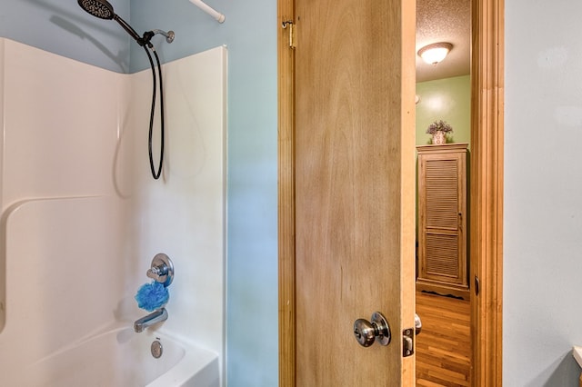 243 Havenwood Ln, Murphy, NC 28906 - bathroom with washtub / shower combination, a textured ceiling, and wood finished floors