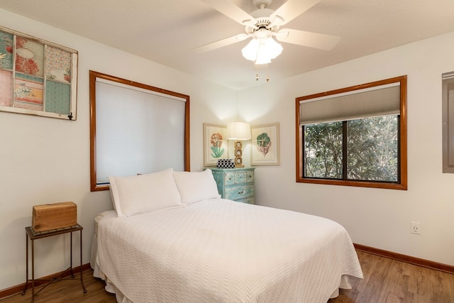 bedroom with ceiling fan, baseboards, and wood finished floors