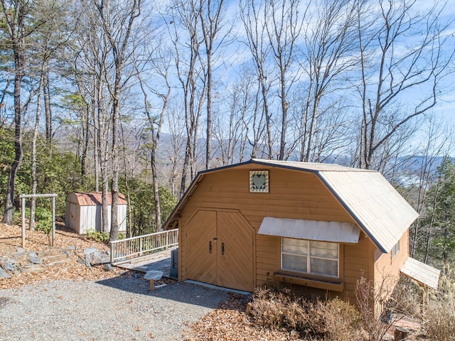 view of front of house featuring metal roof, a shed, and an outdoor structure