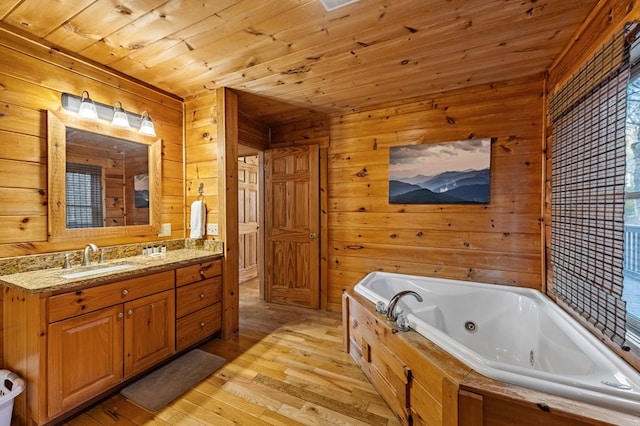 full bathroom with a jetted tub, wood finished floors, wooden walls, wood ceiling, and vanity