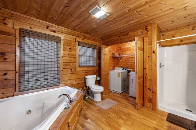 bathroom with a shower stall, washer and clothes dryer, toilet, wooden ceiling, and wood finished floors