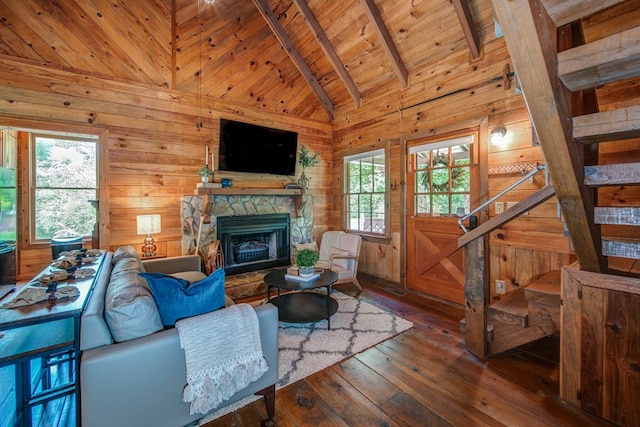 living room with a stone fireplace, wood-type flooring, high vaulted ceiling, wooden ceiling, and wooden walls