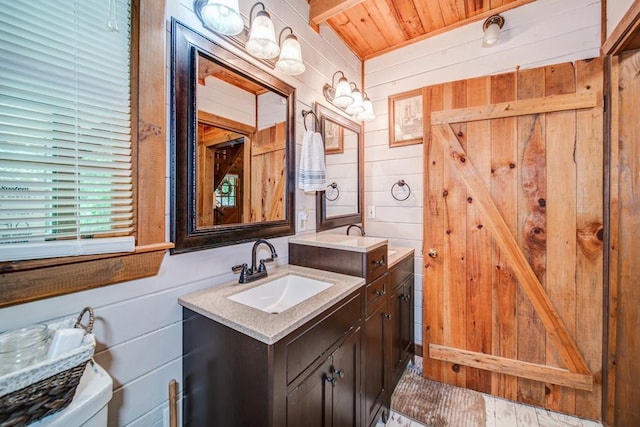 bathroom with vanity, wooden walls, and toilet