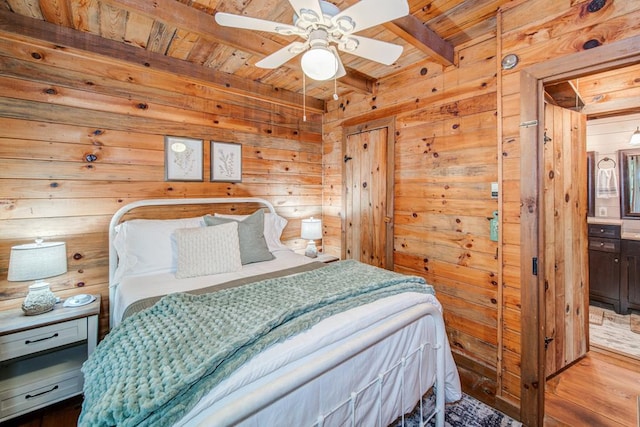 bedroom featuring beamed ceiling, wood-type flooring, wooden walls, and wooden ceiling