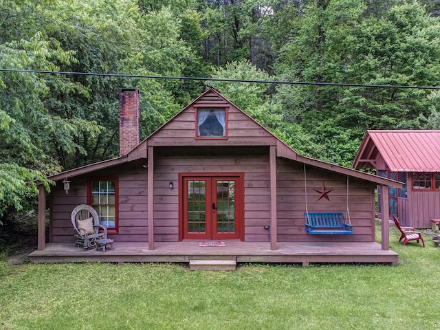 view of outbuilding with french doors and a lawn