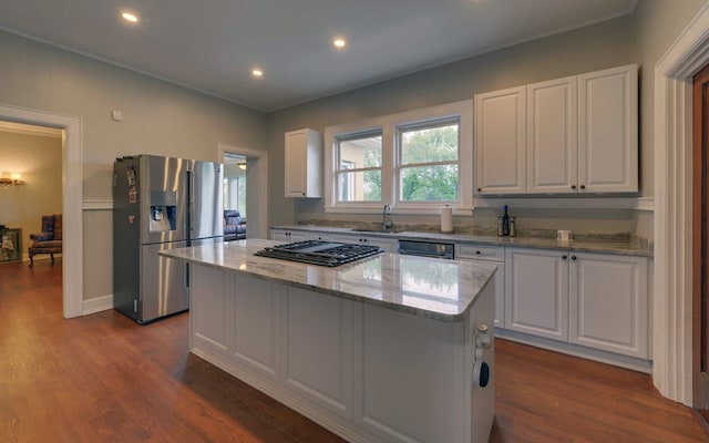 kitchen with hardwood / wood-style floors, appliances with stainless steel finishes, a center island, and white cabinetry