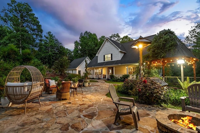 patio terrace at dusk featuring an outdoor fire pit