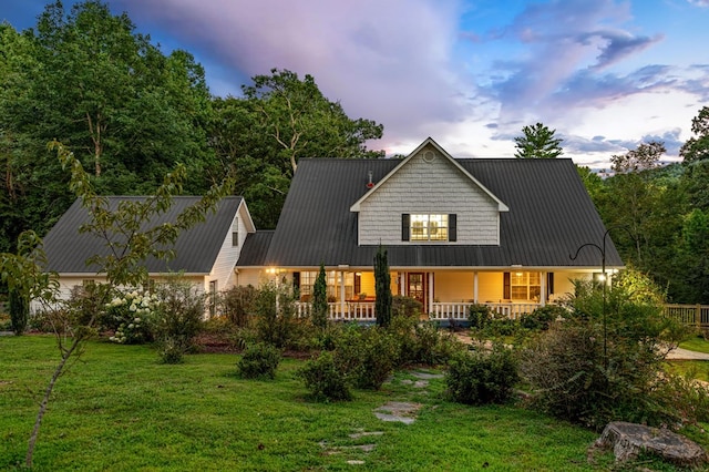 view of front of house featuring metal roof, a porch, and a front yard