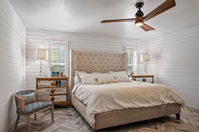 bedroom featuring ceiling fan, multiple windows, and a textured ceiling