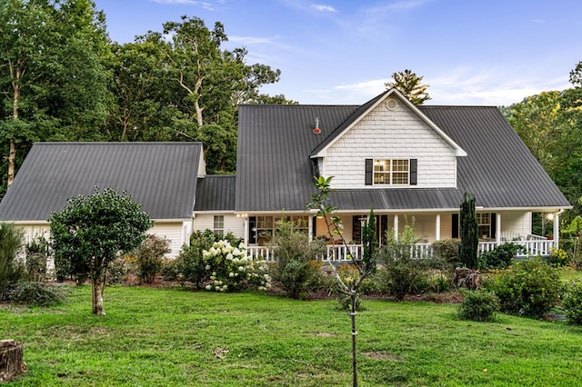 view of front facade with a front yard, covered porch, and metal roof