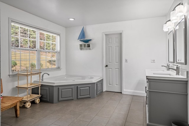 bathroom with tile patterned floors, vanity, baseboards, and a bath