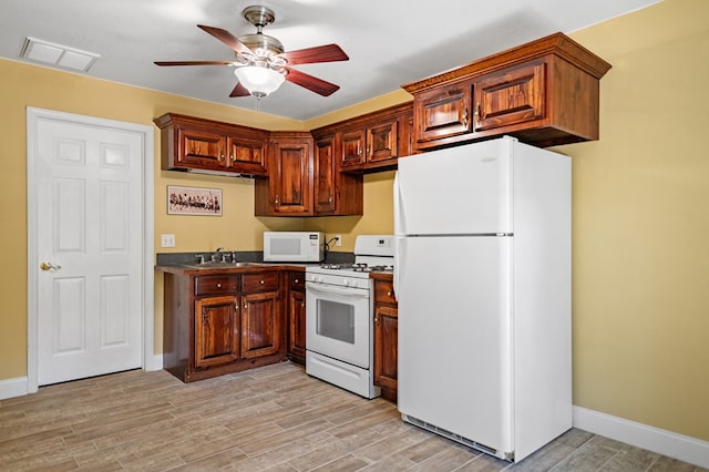 kitchen with white appliances, visible vents, a ceiling fan, dark countertops, and light wood-style floors