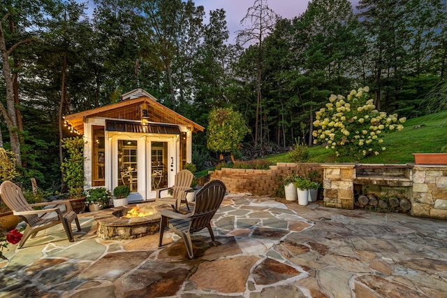 view of patio / terrace featuring an outbuilding and an outdoor fire pit