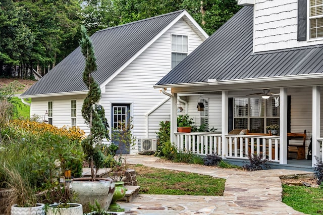 view of front of house with ac unit, covered porch, metal roof, and a standing seam roof