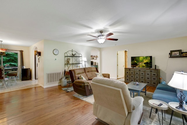 49 Hampton Ln, Hayesville, NC 28904 - living area with arched walkways, light wood finished floors, ceiling fan, and baseboards