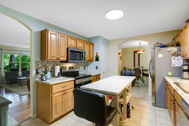 49 Hampton Ln, Hayesville, NC 28904 - kitchen featuring stainless steel appliances, arched walkways, backsplash, light tile patterned flooring, and pendant lighting