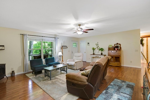 49 Hampton Ln, Hayesville, NC 28904 - living room with hardwood / wood-style floors, a ceiling fan, a wood stove, and baseboards