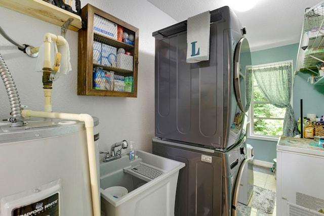49 Hampton Ln, Hayesville, NC 28904 - laundry room featuring water heater, stacked washer / dryer, light tile patterned floors, and baseboards