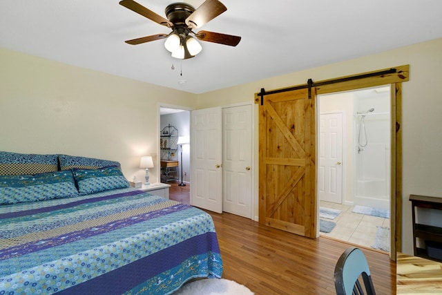 49 Hampton Ln, Hayesville, NC 28904 - bedroom featuring a barn door, light wood finished floors, a ceiling fan, and ensuite bath