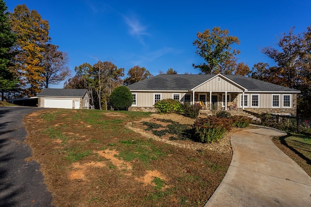 ranch-style home with an outbuilding, covered porch, and a garage