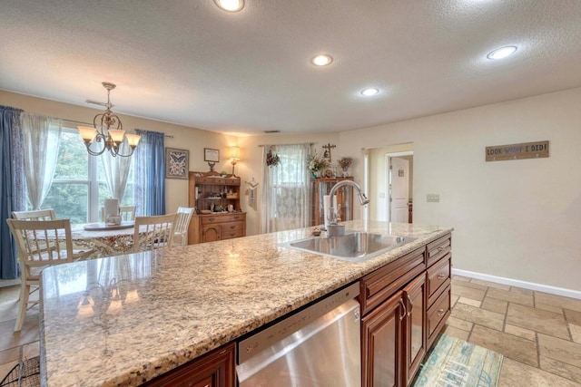 kitchen featuring light stone countertops, sink, hanging light fixtures, an inviting chandelier, and stainless steel dishwasher