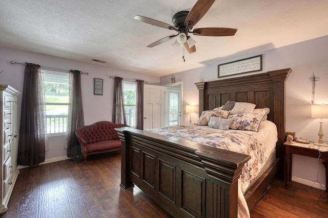 bedroom featuring ceiling fan, dark hardwood / wood-style flooring, and a textured ceiling