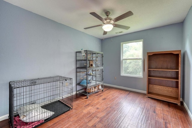 misc room featuring wood-type flooring and ceiling fan