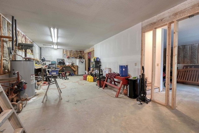 basement featuring a workshop area, electric water heater, white fridge, and a textured ceiling