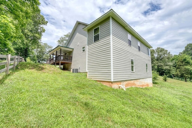 view of side of property featuring a yard and central AC unit