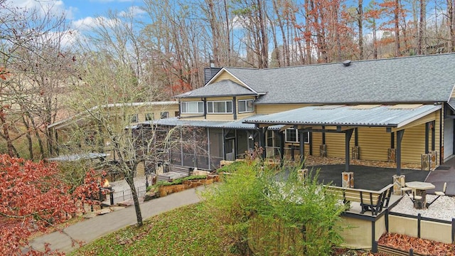 rear view of house featuring a sunroom