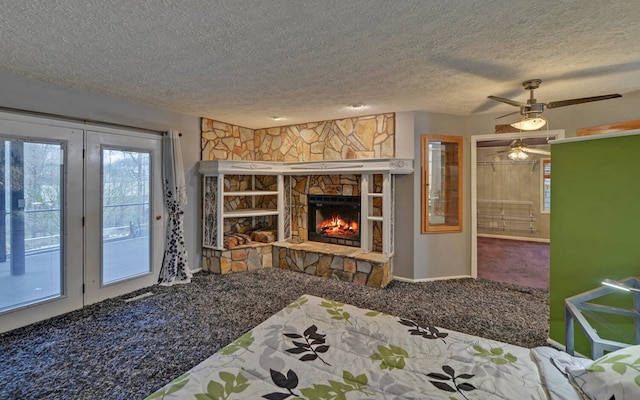 interior space featuring carpet, a textured ceiling, a fireplace, and ceiling fan