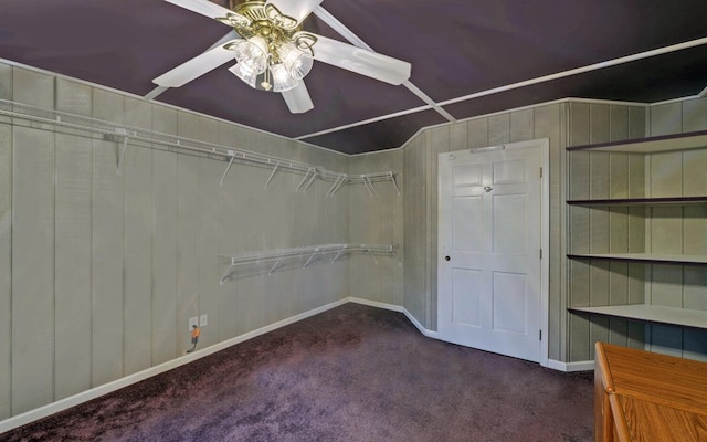 walk in closet featuring dark colored carpet and ceiling fan