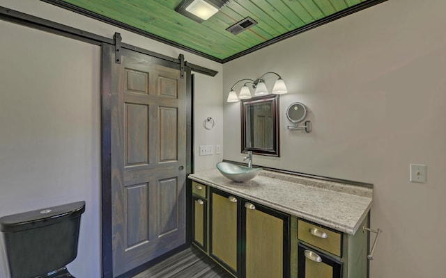 bathroom with toilet, vanity, and ornamental molding