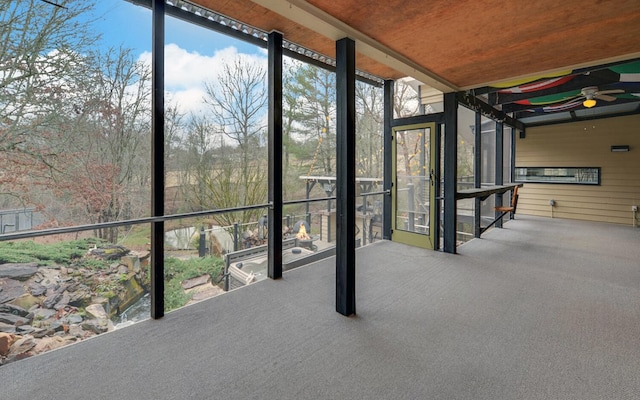 unfurnished sunroom with ceiling fan