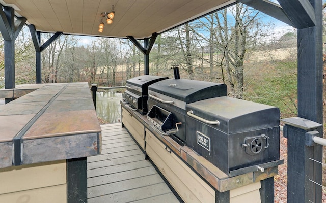 wooden terrace featuring grilling area and exterior kitchen