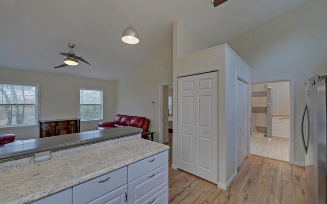 kitchen featuring ceiling fan, light hardwood / wood-style flooring, stainless steel fridge, decorative light fixtures, and white cabinets