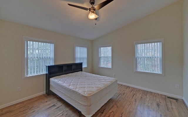 bedroom with ceiling fan, light hardwood / wood-style flooring, and lofted ceiling