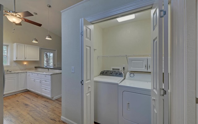 clothes washing area featuring ceiling fan, light hardwood / wood-style floors, a high ceiling, and independent washer and dryer