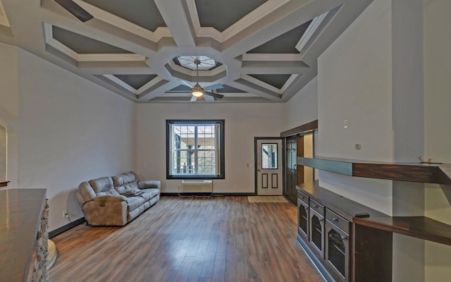 unfurnished living room featuring ceiling fan, wood-type flooring, ornamental molding, and coffered ceiling