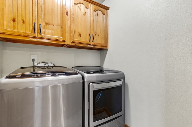 washroom featuring cabinets and washing machine and clothes dryer