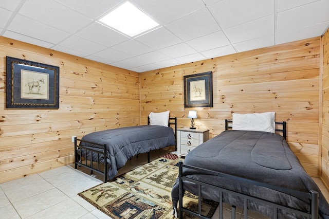 tiled bedroom with a drop ceiling and wood walls