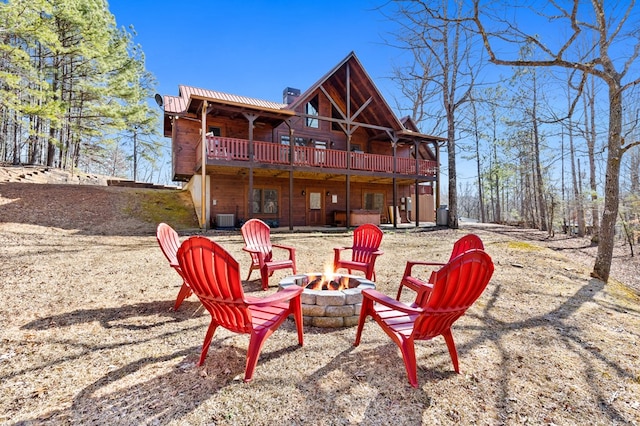 exterior space featuring a patio, a deck, central air condition unit, and an outdoor fire pit