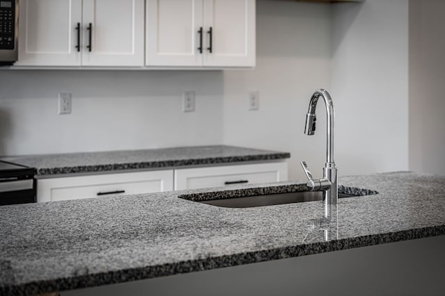 UNIT2 Grove Loop, Blue Ridge, GA 30513 - kitchen with dark stone counters, a sink, and white cabinetry