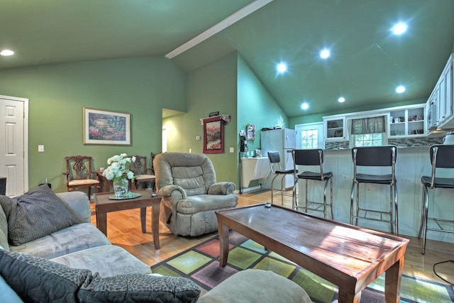 living room with light wood-type flooring and high vaulted ceiling